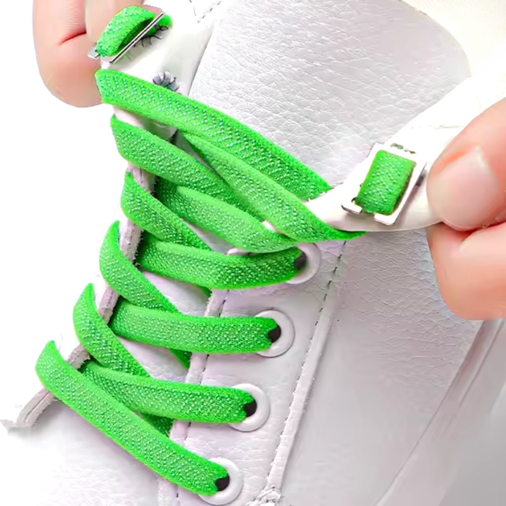 Groene platte elastische veters zonder strikken onzichtbaar gestrikt met clip getoond op een witte schoen