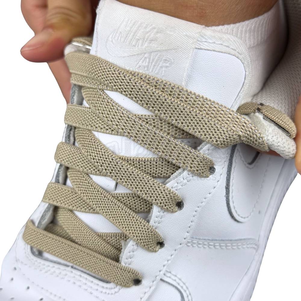 Beige/Khaki Elastische Veters in een Nike Air Force 1 Sneaker uitgerekt om de rekbaarheid te laten zien van de stretch van de elastiek veters