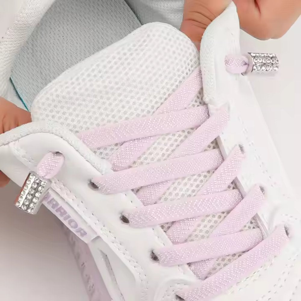 Uitgerekte roze textuur elastische veters zonder strikken met ronde sluiting en rhinestone steentjes getoond op schoen